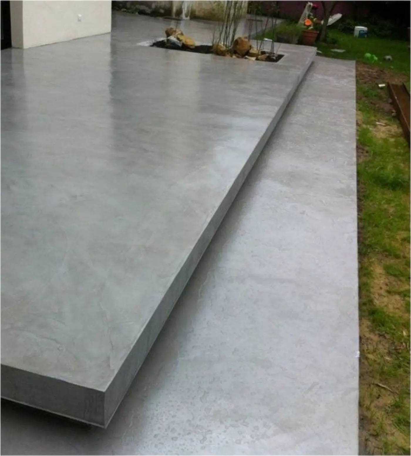 Allée de villa en béton ciré extérieur patinée après plusieurs saisons, entretien au savon neutre