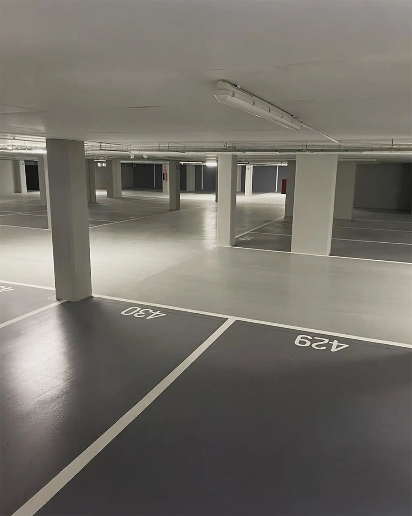 Parking couvert au sol en résine époxy quartz antidérapante avec marquage intégré